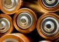 Close-up of several cylindrical batteries lying side by side on a surface