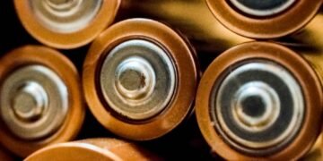 Close-up of several cylindrical batteries lying side by side on a surface
