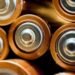 Close-up of several cylindrical batteries lying side by side on a surface