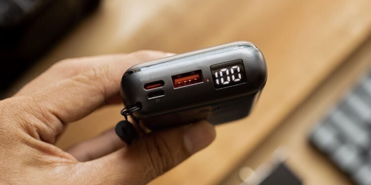 Close-up of a portable power bank with a lit digital display