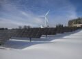 Solar panels standing in a snowy field in winter under a clear sky