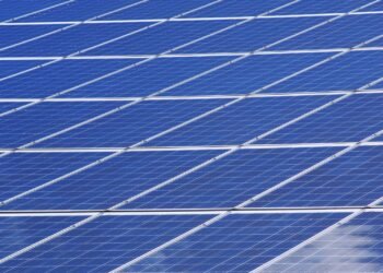 Blue solar panels set up outdoors under a bright, clear sky
