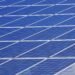 Blue solar panels set up outdoors under a bright, clear sky
