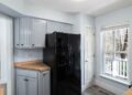 A standalone refrigerator standing inside a room at home