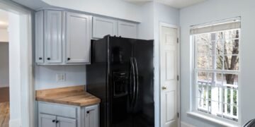 A standalone refrigerator standing inside a room at home