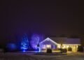 House exterior at night with lights on, powered after dark by solar batteries