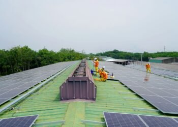 Workers installing solar panels on a roof