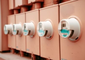 Close-up of a row of electricity meters mounted side by side on a wall