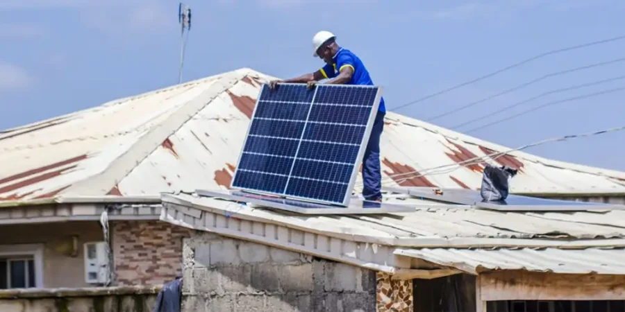 Technicians installing solar panels on a residential rooftop under clear skies.