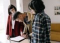 Man signing loan documents beside a woman while an agent looks on