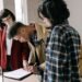 Man signing loan documents beside a woman while an agent looks on