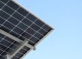 Rear view of a solar panel installation against a clear blue sky