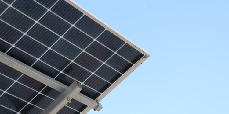 Rear view of a solar panel installation against a clear blue sky
