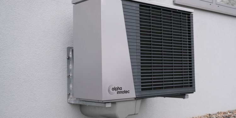 Outdoor air conditioner unit mounted on an exterior building wall in sunlight