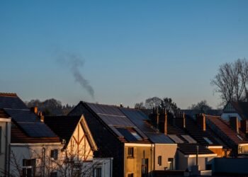 Row of suburban houses with solar panels installed on their roofs