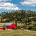 Red wooden shed standing on open farmland under the sky