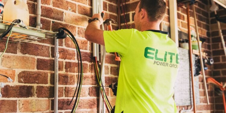 Electrician installing a home solar battery storage system on a wall