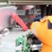 Technician checking and maintaining a wall-mounted solar inverter and its wiring